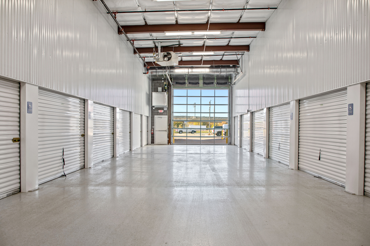 Indoor drive-through corridor of a self storage facility with garage door open to outside